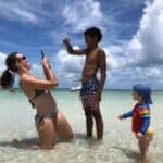 Guests taking photos together in shallow water at a Key West sandbar