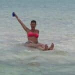 Guest standing in shallow Key West sandbar water with an arm raised