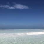 Shallow water and sandbar visible under a dark sky in Key West