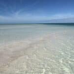 Sandbar in Key West at nightfall with shallow water and a deep blue sky