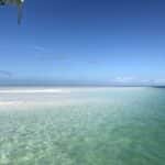 Sandbar in Key West at sunset with deep blue sky and glowing shallow water